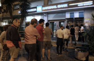 Πολίτες περιμένουν έξω από ΑΤΜ τράπεζας στην Αθήνα για να κάνουν ανάληψη χρημάτων ξημερώματα Σαββάτου 27 Ιουνίου 2015, μετά την ανακοίνωση από τον πρωθυπουργό Αλέξη Τσίπρα για τη διενέργεια δημοψηφίσματος την Κυριακή 5 Ιουλίου για την αποδοχή ή την απόρριψη της πρότασης των θεσμών.